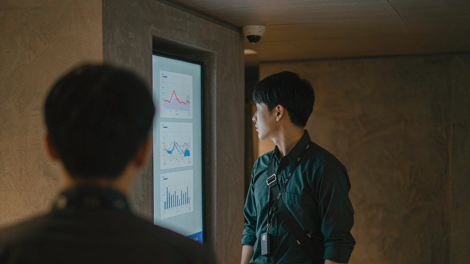 Hotel staff reviewing front-desk queue metrics on a monitor